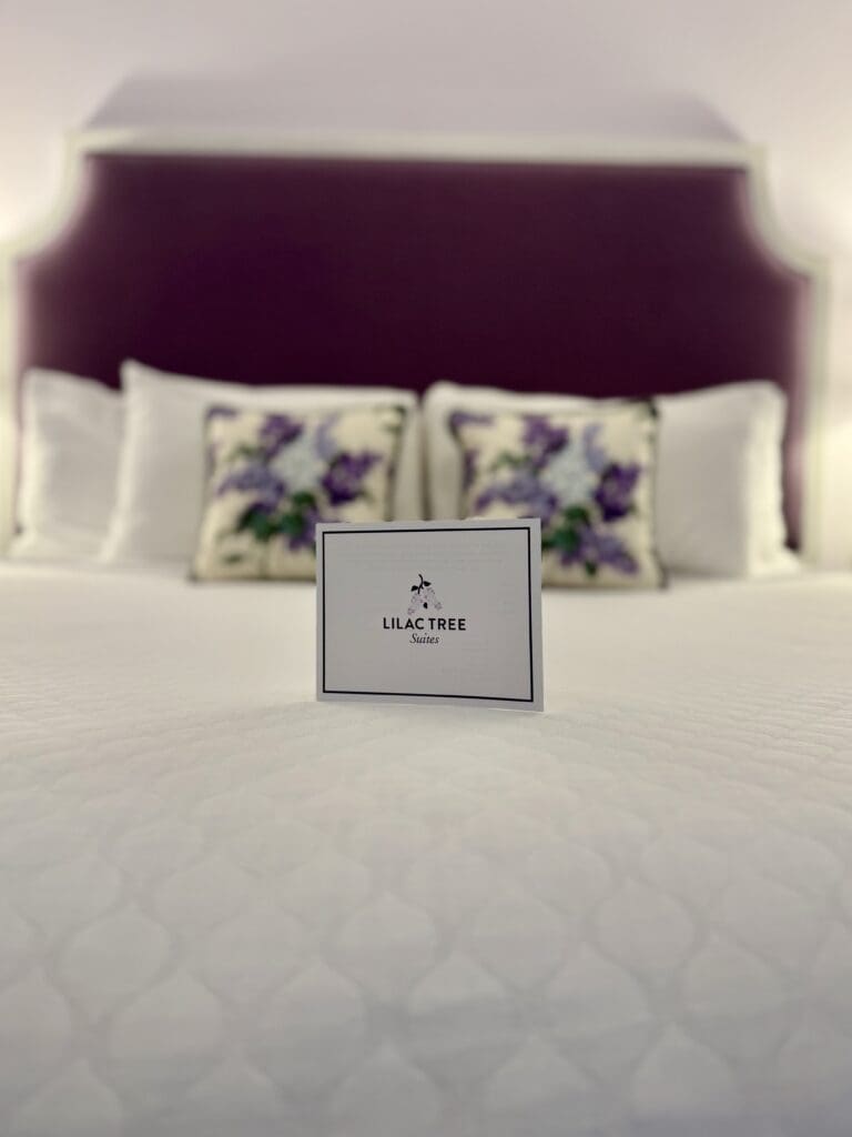 image3 Lilac Tree Suites King Size bed with a welcome card on top of the bedspread
