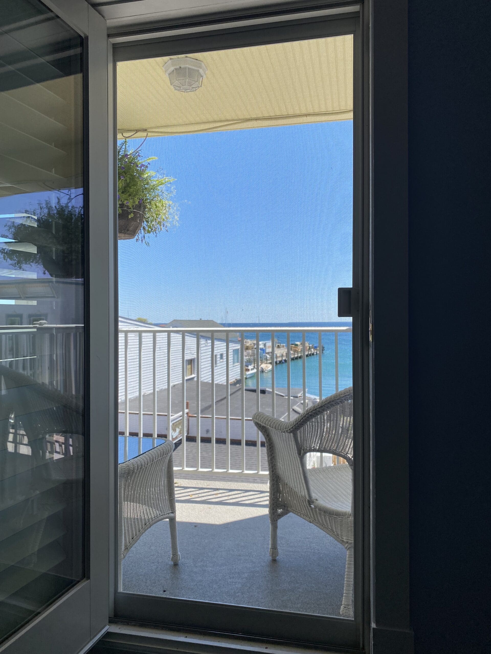 a balcony at the Lilac Tree Suites with 2 chairs and a table looking out towards Main Street and the lake